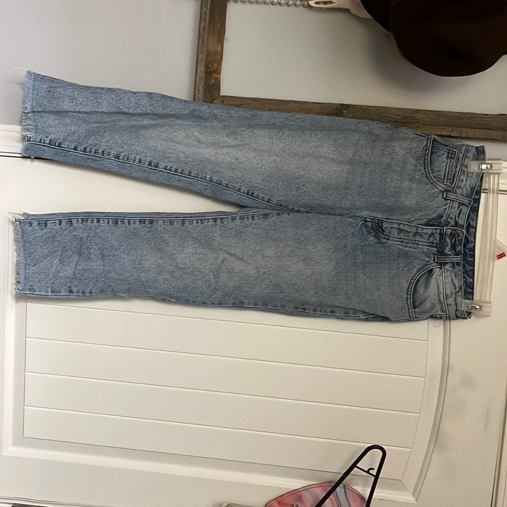 Light washed blue jeans. They have 5 buttons going up. Fringe on the bottom.